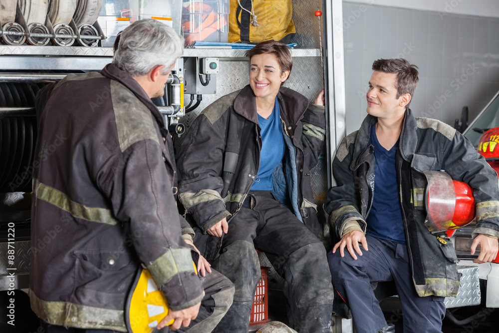 Obraz premium Happy Firefighters Conversing By Firetruck