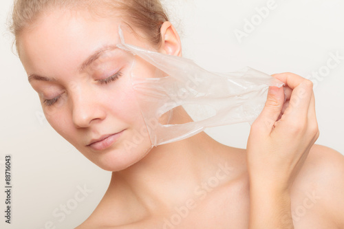 фотографія girl removing facial peel off mask