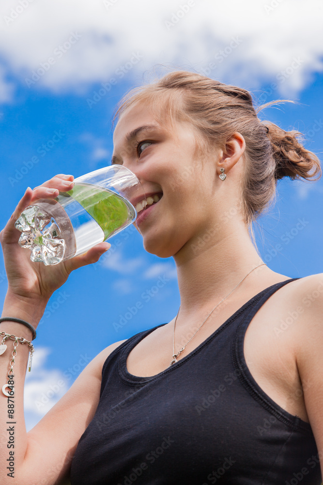 Teenage girl drinking a glass of water Teenage girl drinking a glass of water