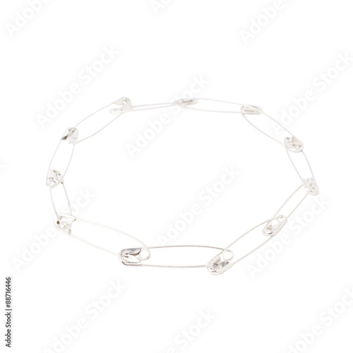 Round frame made of safety pins isolated on white background