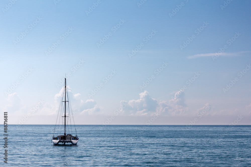 Single high-mast catamaran cruises in tropical waters