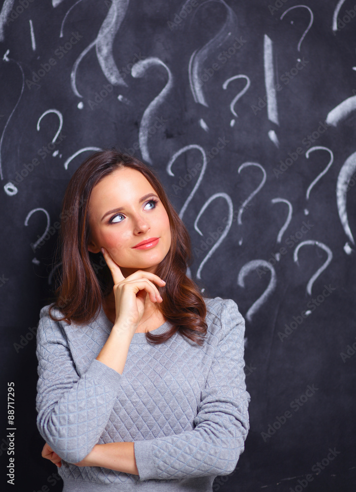 Young girl with question mark on a gray background Young girl with question mark on a gray background