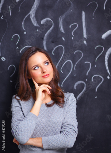 Young girl with question mark on a gray background