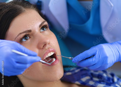 Woman dentist working at her patient teeth
