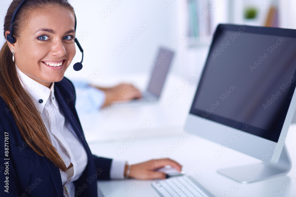 Happy female wearing headset and sitting on the desk