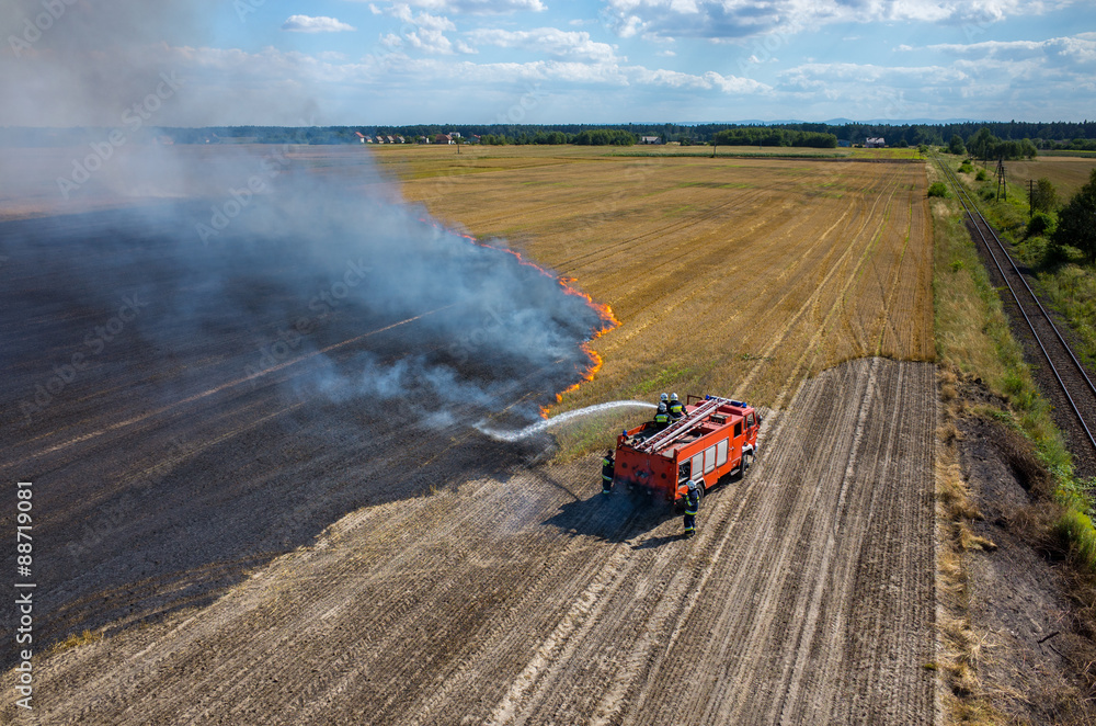 Fototapeta premium Fireman truck working on the field on fire