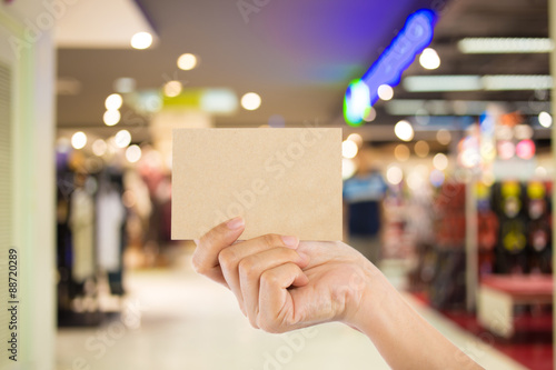 Photo blank. Hand hold blank business card in the shopping mall. © patcharaporn1984