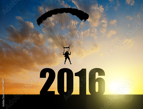 Silhouette skydiver parachutist landing in the New Year 2016 