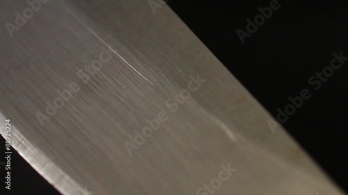 'CUTTING EDGE TECHNOLOGY' (Metaphor) - Macro close up camera dolly move along a sharp stainless steel knife blade; return to 1st position