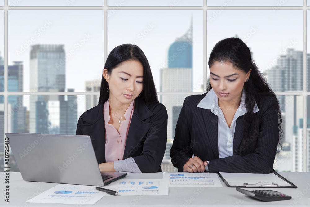 Two businesswomen working at workplace Two businesswomen working at workplace