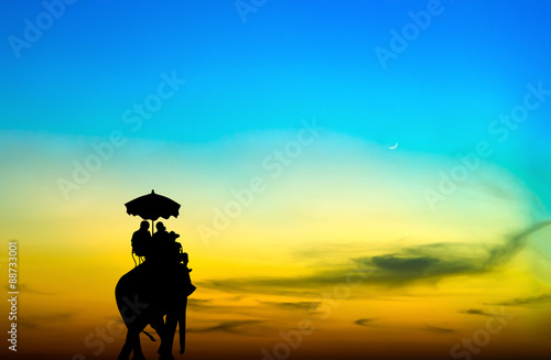 silhouette elephant with tourist at sunset