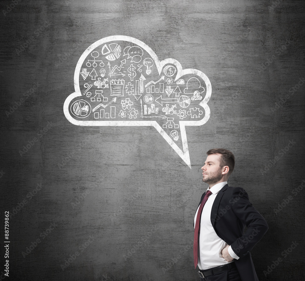Side view of the confident businessman, student, who is thinking about new business concepts. Drawn cloud with business icons on the black chalkboard. Side view of the confident businessman, student, who is thinking about new business concepts. Drawn cloud with business icons on the black chalkboard.
