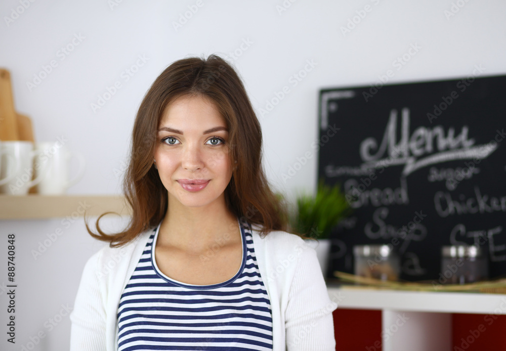 Young woman standing in kitchen at home