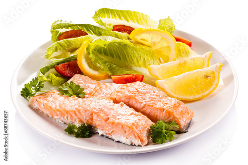 Roasted salmon and vegetables on white background