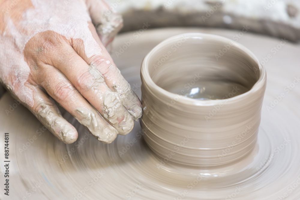 Making a pottery cup on the wheel
