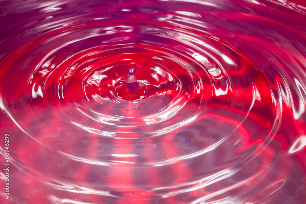 Cerchi concentrici creati da una goccia d'acqua. Acqua rossa Cerchi concentrici creati da una goccia d'acqua. Acqua rossa