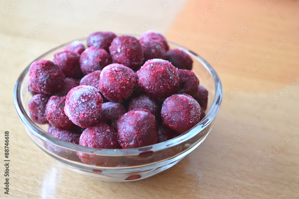 Frozen cherries in a glass bowl on wooden table Frozen cherries in a glass bowl on wooden table