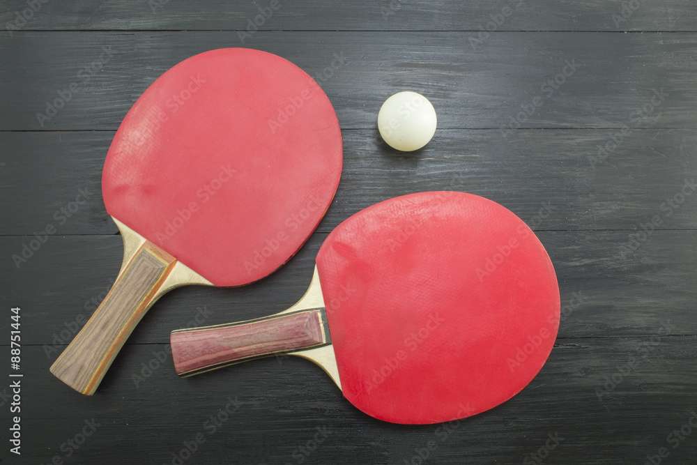 Two red table tennis rackets on dark background Two red table tennis rackets on dark background