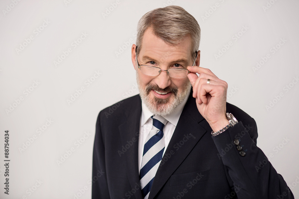 Senior male entrepreneur adjusting eyeglasses Senior male entrepreneur adjusting eyeglasses