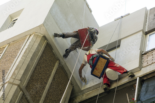 two high workers making repairs on a facade