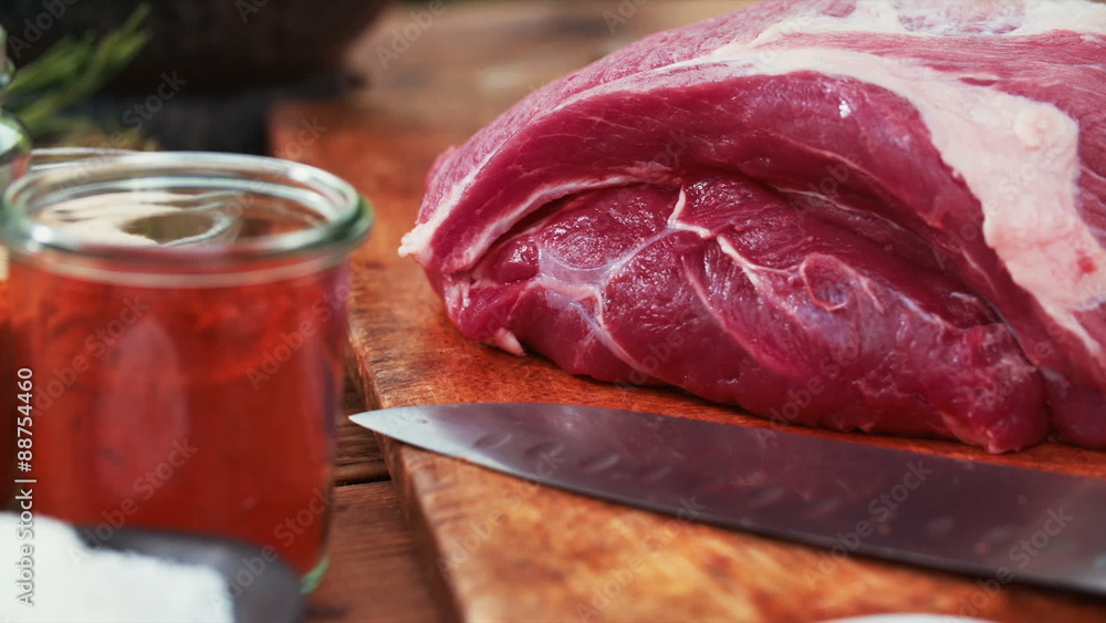 Fresh cut piece of raw pork with herbs and seasonings Fresh cut piece of raw pork with herbs and seasonings