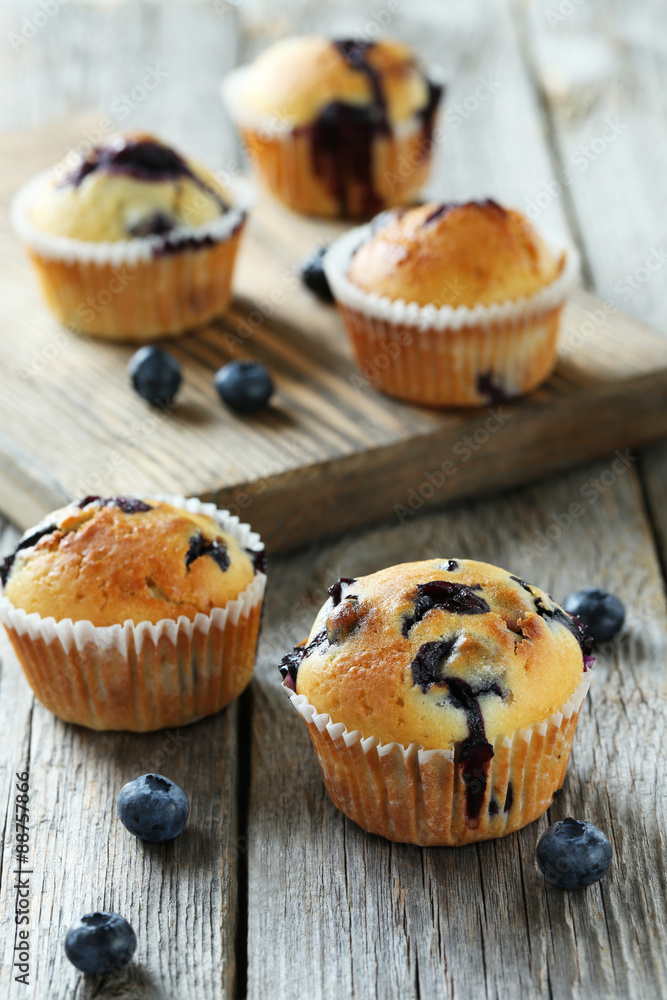 Tasty blueberry muffins on a grey wooden background Tasty blueberry muffins on a grey wooden background