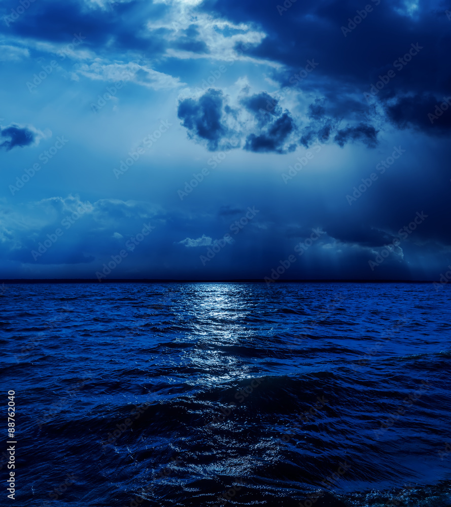 Fototapeta premium moonlight in clouds over water