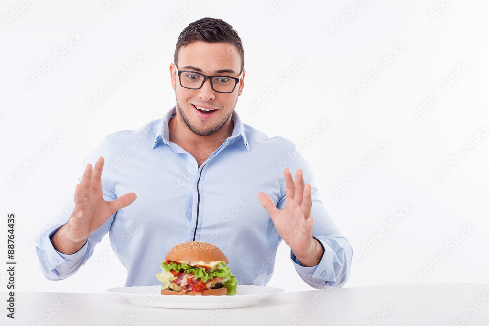 Cheerful young fit man is very hungry