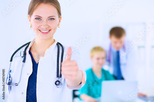 Female doctor shows a sign okay standing in hospital photo