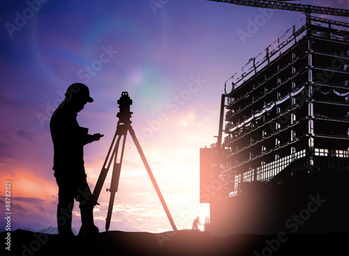 silhouette survey engineer working  in a building site over Blur photo
