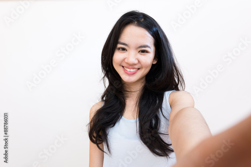 An asian woman taking self portrait isolated on white