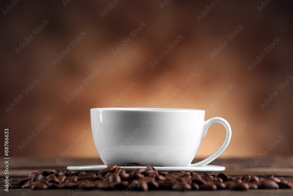Fototapeta premium Cup of coffee and beans on blurred background