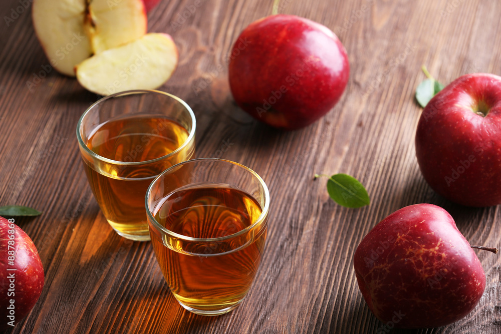 Glasses of apple juice and fruits on table close up Glasses of apple juice and fruits on table close up