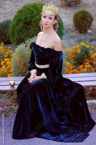 Elegant young woman dressed like queen photo