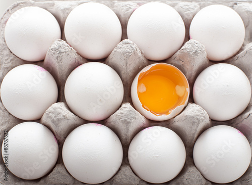 A dozen of eggs in carton showing yolk
