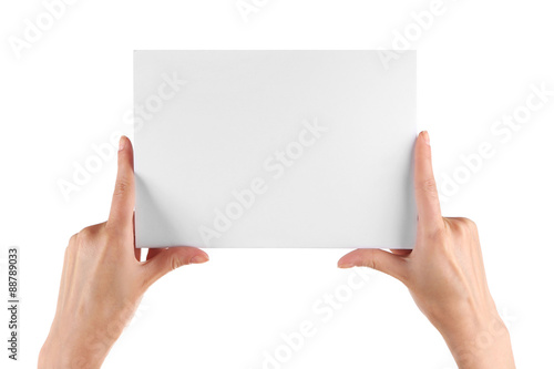 Female hand holding paper blank isolated on white