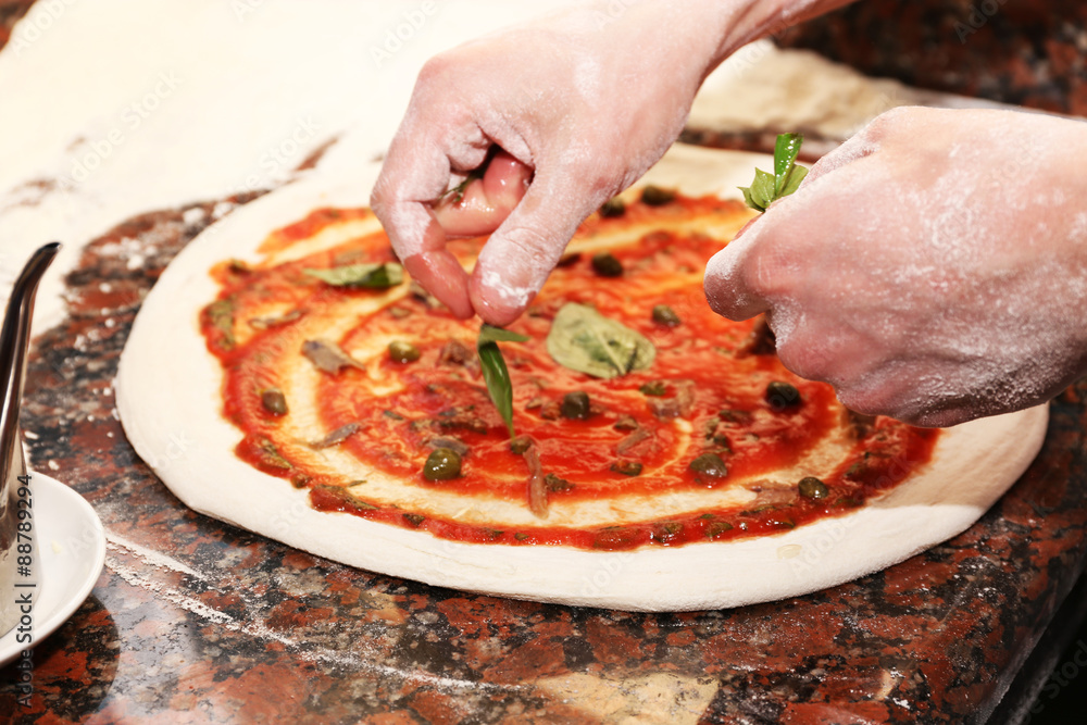Chef preparing pizza on marble table, closeup Chef preparing pizza on marble table, closeup
