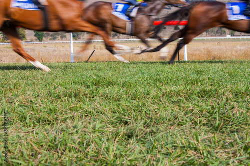 Fototapet Horses race past in a blur with room for copy below