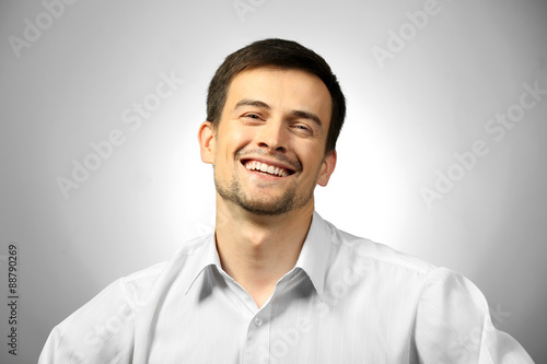 Handsome young man on gray background © Africa Studio