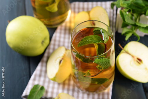 Glasses of apple juice with fruits and fresh mint on table close up