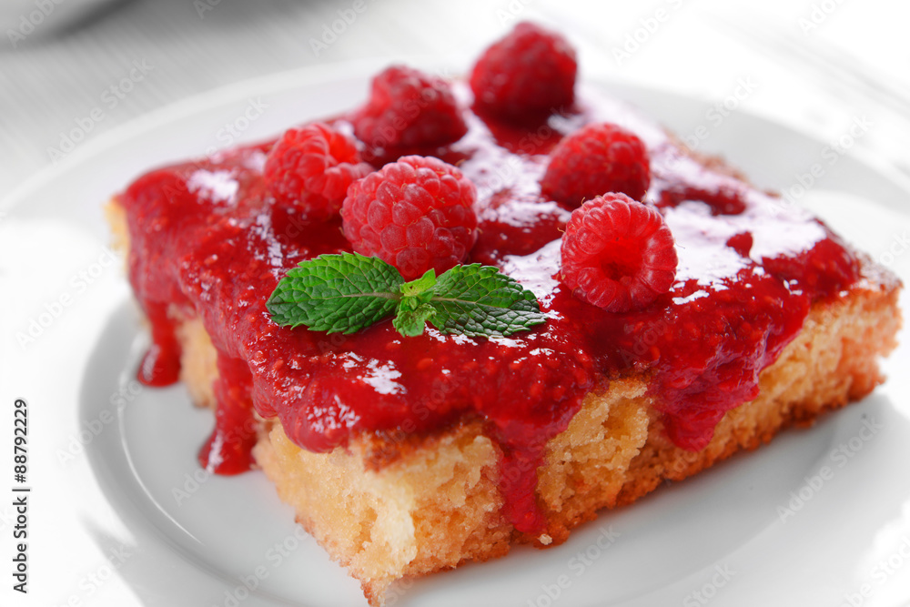 Fresh pie with raspberry jam in white saucer on wooden table, closeup Fresh pie with raspberry jam in white saucer on wooden table, closeup