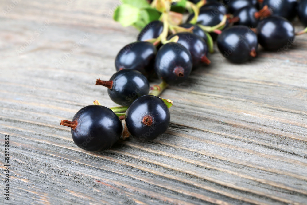 Pile of black currants on wooden table, closeup