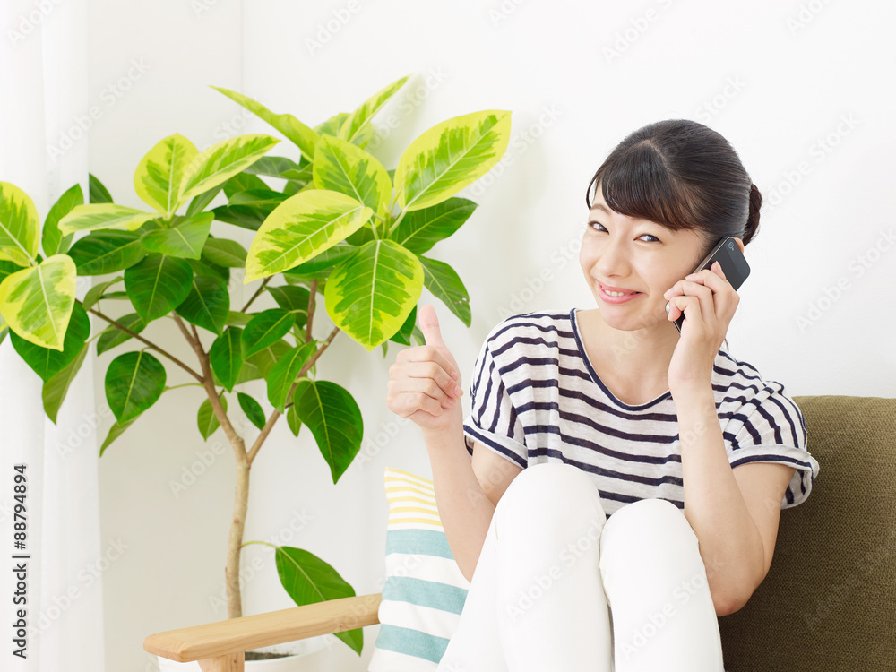 スマートフォンを使う女性　グッドサイン