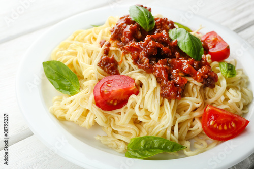 Spaghetti Bolognese on white plate  on color wooden background