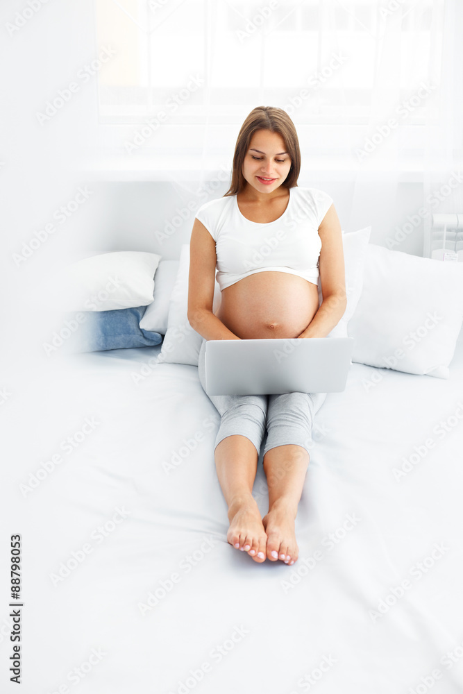 Pregnant Woman With Laptop Computer. Beautiful Pregnant Woman Working on Laptop at Home Pregnant Woman With Laptop Computer. Beautiful Pregnant Woman Working on Laptop at Home