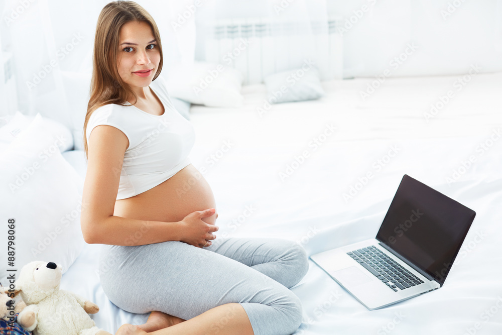 Pregnant Woman With Laptop Computer. Beautiful Pregnant Woman Working on Laptop at Home Pregnant Woman With Laptop Computer. Beautiful Pregnant Woman Working on Laptop at Home