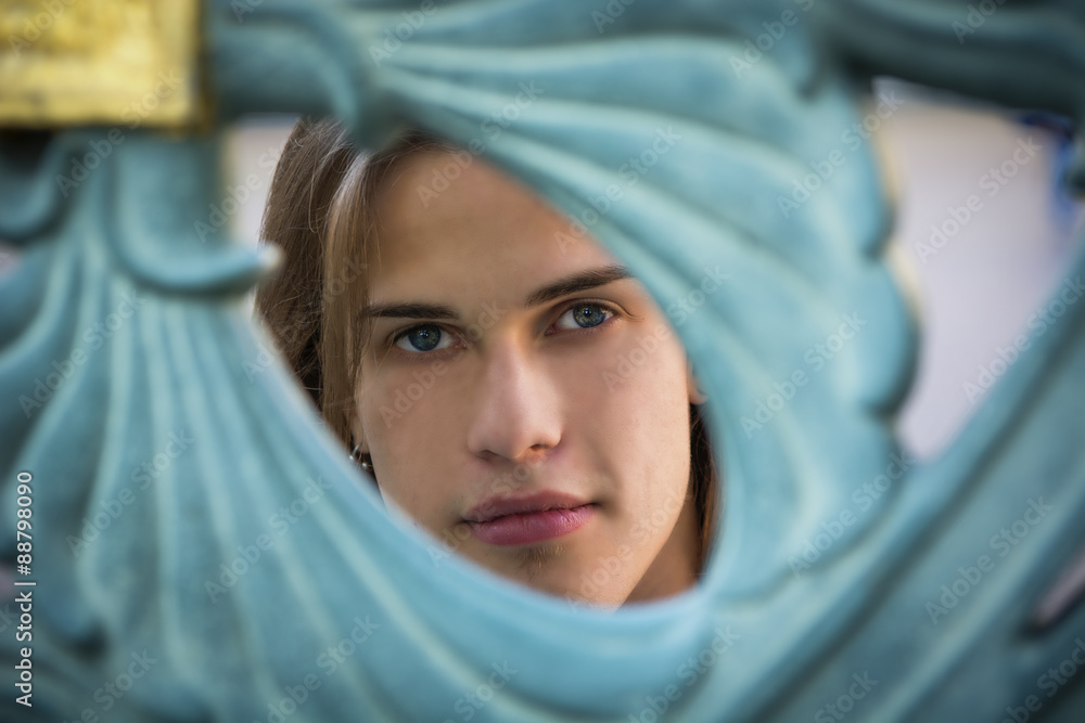 Fototapeta premium Gorgeous Long Hair Man Peeking Through Hole