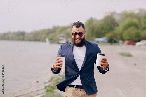 bearded man carrying coffee