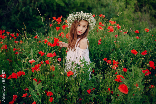 beautiful little girl posing in a skirt wreath of poppies
