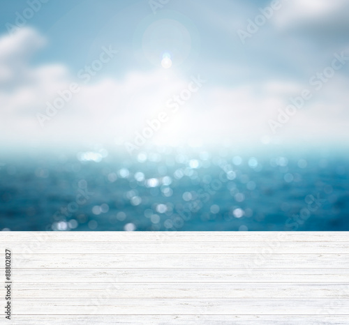 Blurred blue sea and sky with space on wooden table.